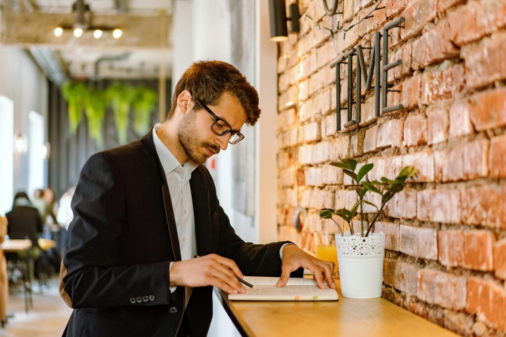 What Is A Virtual Assistant - Man Stood at Desk Making Notes