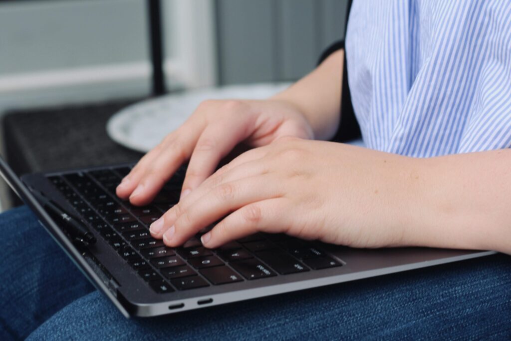 What Is A Virtual Assistant - Person Typing On Laptop On Their Lap